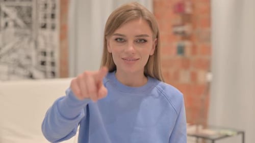 Woman Points at the Camera Wearing Blue Sweater