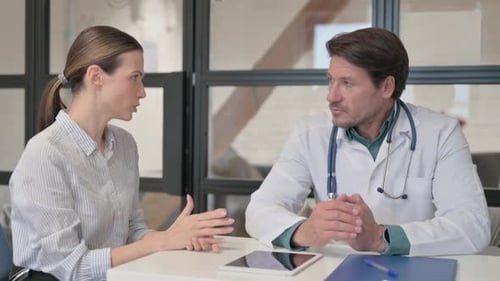 Doctor Listening Female Patient in Clinic