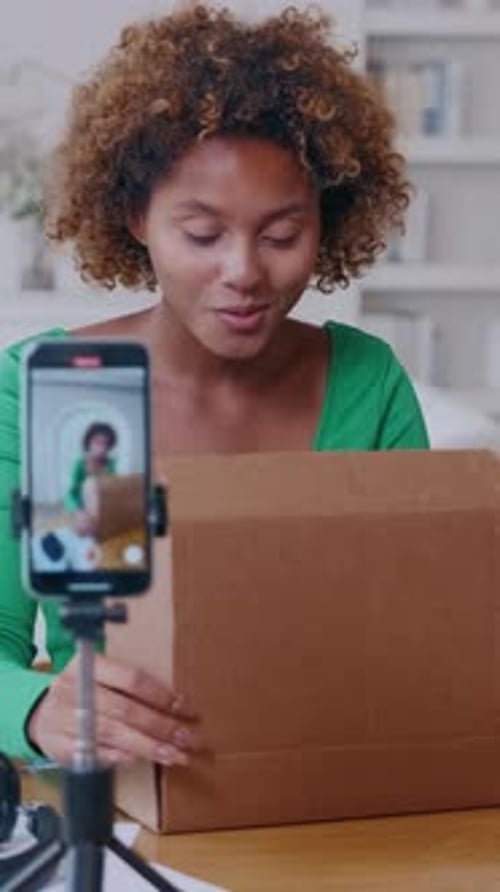Young Female Records Unboxing Video in a Home Studio Opening a Cardboard Box