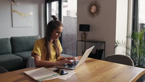 Young Woman Working on Laptop at Home