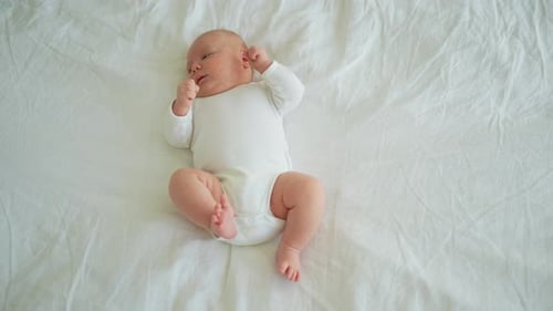 Sweet Infant Lying on White Bedding, Birds Eye View