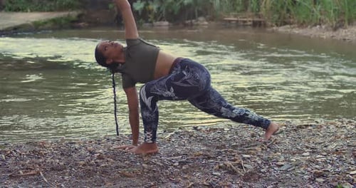 A girl finding inner peace through yoga by a sunlit river in the Caribbean.
