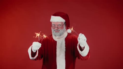 Santa Claus Celebrates with Sparklers on Red Background