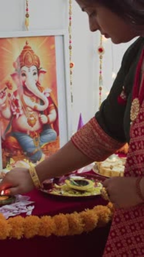 Indian Woman Lighting Diwali Candles on Altar