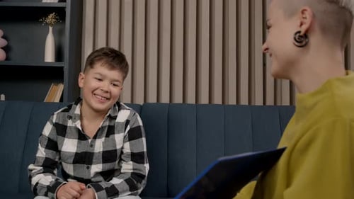 Psychologin macht Psychotherapie mit einem schwarzen Jungen mithilfe von Emotionskarten