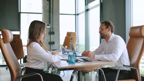 Business Meeting Between Colleagues Make a Deal and Shake Hands in a Modern Office Setting During