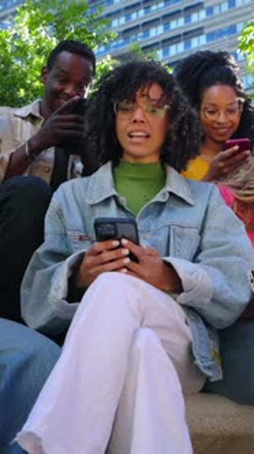 Friends Gathered Looking at Mobile Phone Outside