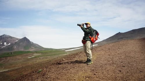 Photographer Exploring Mountainous Landscape on Sunny Day