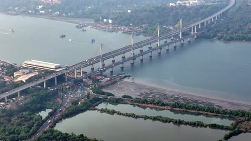 Wide aerial of the entire Atal Setu bridge cutting across a serene Mandovi River, with structured