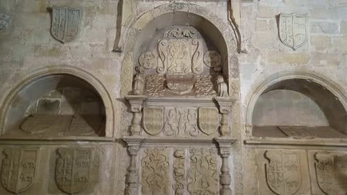 Tombs and Heraldic shields carved in stone. Wiew of a wall with medieval tombs. Spain.