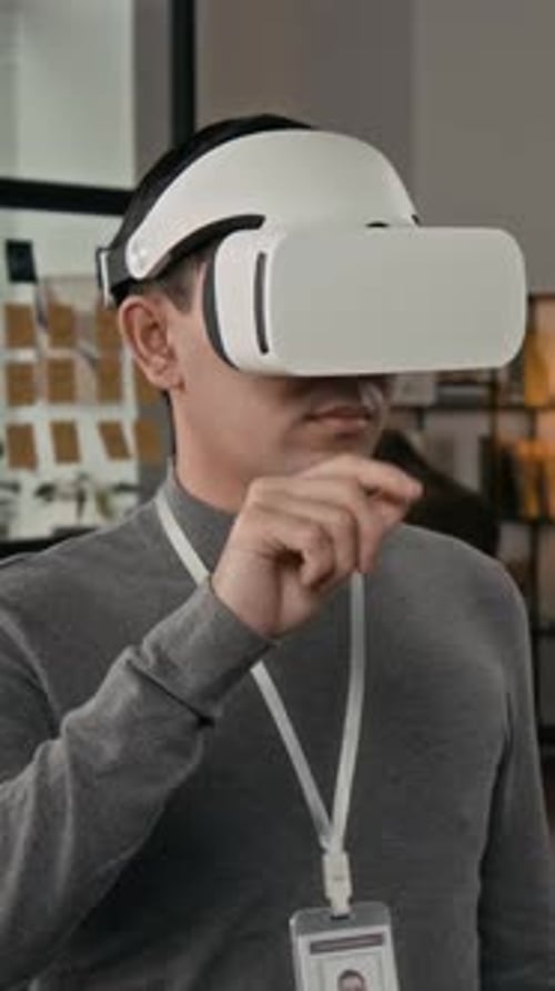 Vertikal eines männlichen Webdesigners der Generation Z, der ein Spiel mit einem VR-Headset entwickelt