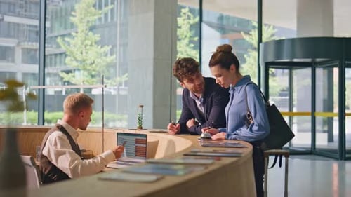 Smiling Couple Talking Hotel Reception Joyful Clients Checking in Writing Forms