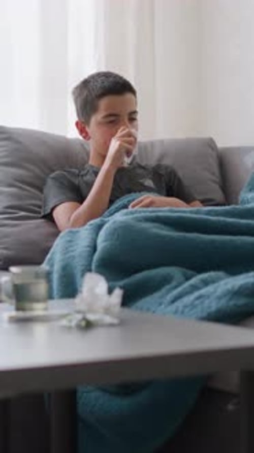 Sick Teenager Lies on Couch with Flu