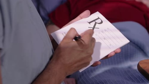 Male doctor writes a prescription in a bright modern doctor's office