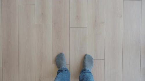 Casual Feet Resting on Lightcolored Wooden Flooring That Adds Comfort to Any Space