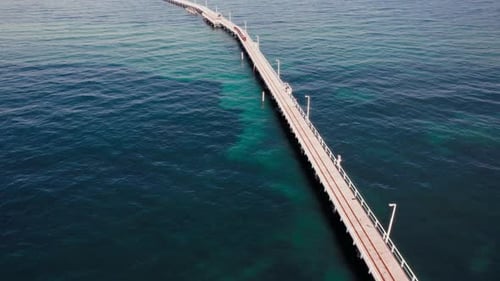 Píer que se estende sobre águas calmas do oceano