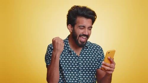 Happy Man Reacts to Good News on Phone