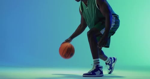 Video eines afroamerikanischen männlichen Basketballspielers, der Ball auf blauem Hintergrund hüpft