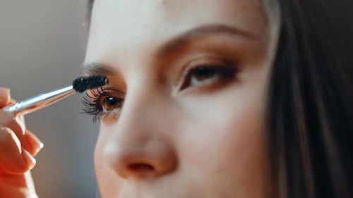 Woman Applying Mascara with Cosmetic Brush Close Up
