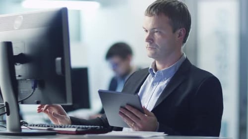 Office Worker is Using Tablet at Work in Office