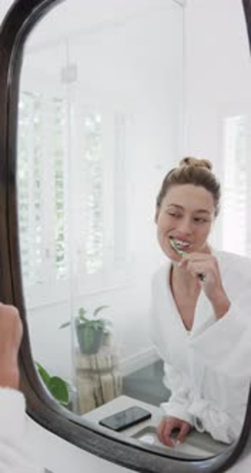 Woman Brushing Teeth in Modern Bathroom