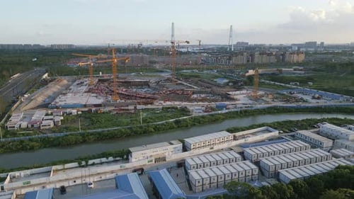 Vista aérea de grúas y sitio de construcción junto a un río chino en Shanghai