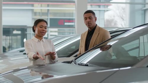 Car Saleswoman Talking to Customer in Dealership