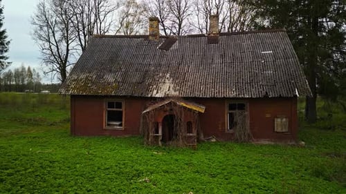 Old Red Brick House with Thatched Roof in Grassy Field