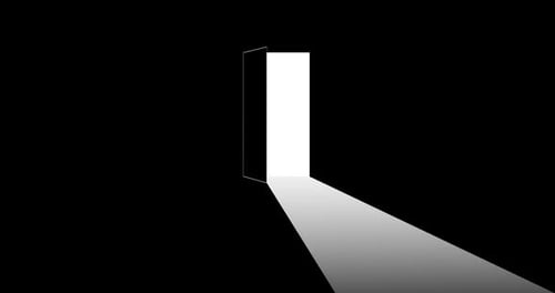 Puerta abierta en un pasillo oscuro que proyecta luz en el suelo