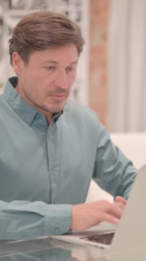 Man Working on Laptop, Turns and Smiles