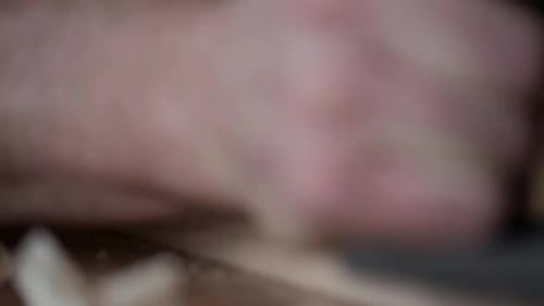 Carpenter smoothing wood block with plane tool in calgary alberta workshop