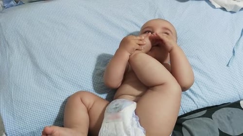 Baby grips foot and tries to chew it