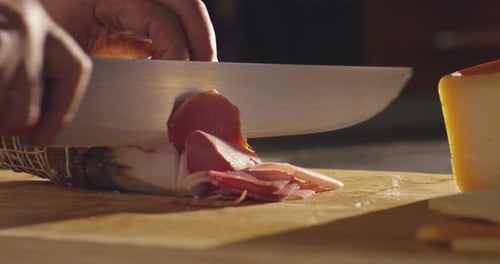Slicing Cured Meat With Knife on Cutting Board