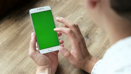 Ein moderner Geschäftsmann verwendet das Handheld-Handy mit Greenscreen-Chromakey und gestikulierender Nahaufnahme