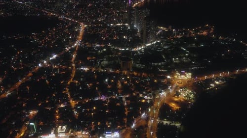 Night city lights drone view. Nightlife residential district, aerial footage.