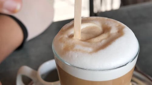 Stirring latte in close up footage