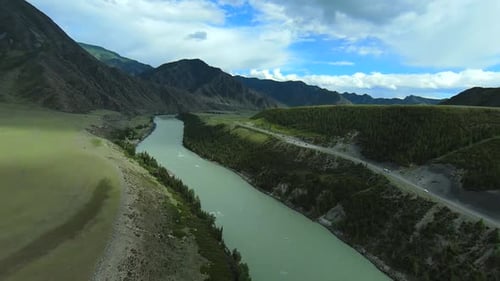 Drone flying over turquoise river flows in intermountains.