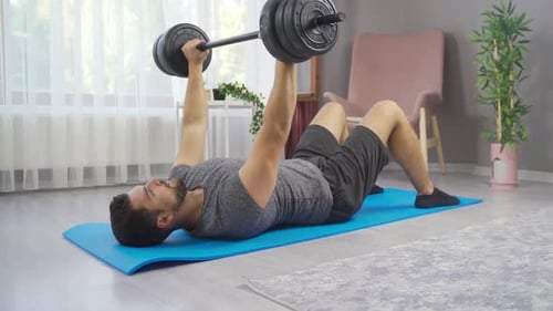 Young Adult Man Doing Bench Press at Home
