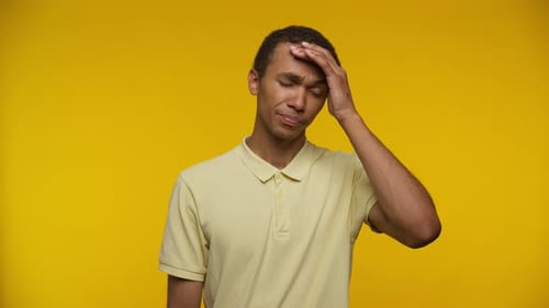 Man Experiencing Headache Against Bright Yellow Background