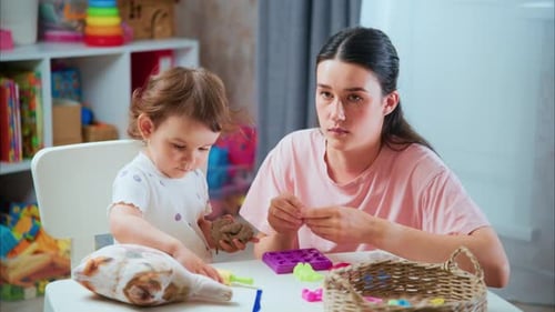 Woman and Child Playing with Clay Indoors