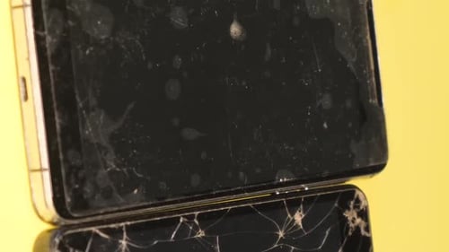 Smartphones Stacked, One with a Cracked Screen