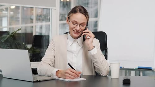 Cheerful Woman Talking on Phone in Office Setting