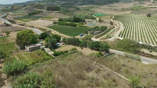 Elevated drone footage showcases agricultural fields and rural roads, offering a bird’s-eye view of