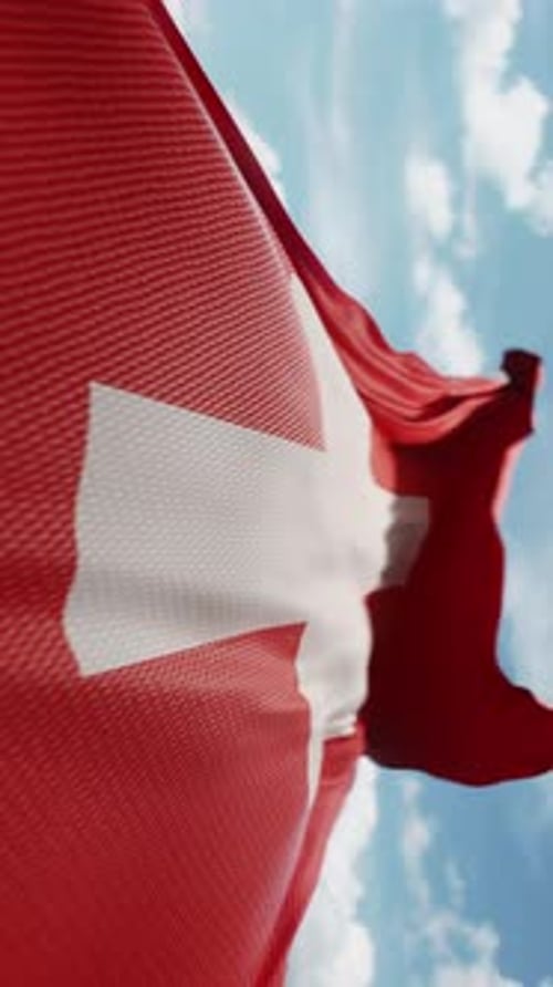 Realistic Swiss Flag Waving Against Blue Sky Vertical Video