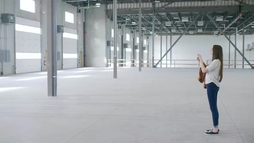 Female Property Owner Photographing Empty Warehouse Loading Dock Adult