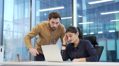 Frustrated Man Arguing with Coworker in Office