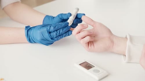 Arzt überprüft den Blutzuckerspiegel eines Diabetikers