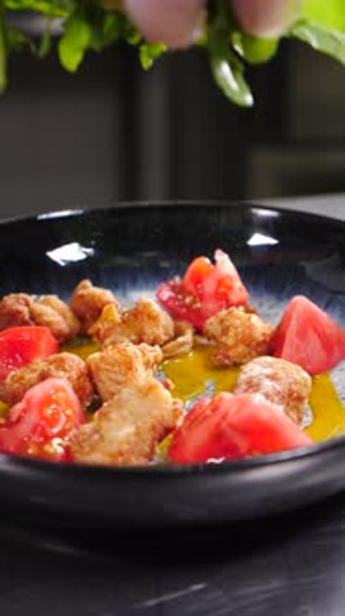 Adding Fresh Greens to Fried Chicken and Tomato Salad