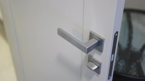 Open Door with Grey Metal Knob and Lock in Room Closeup