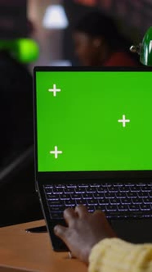 Vertical Video Black Scholar Reading Information Via Internet Next to Chroma Key in a Library